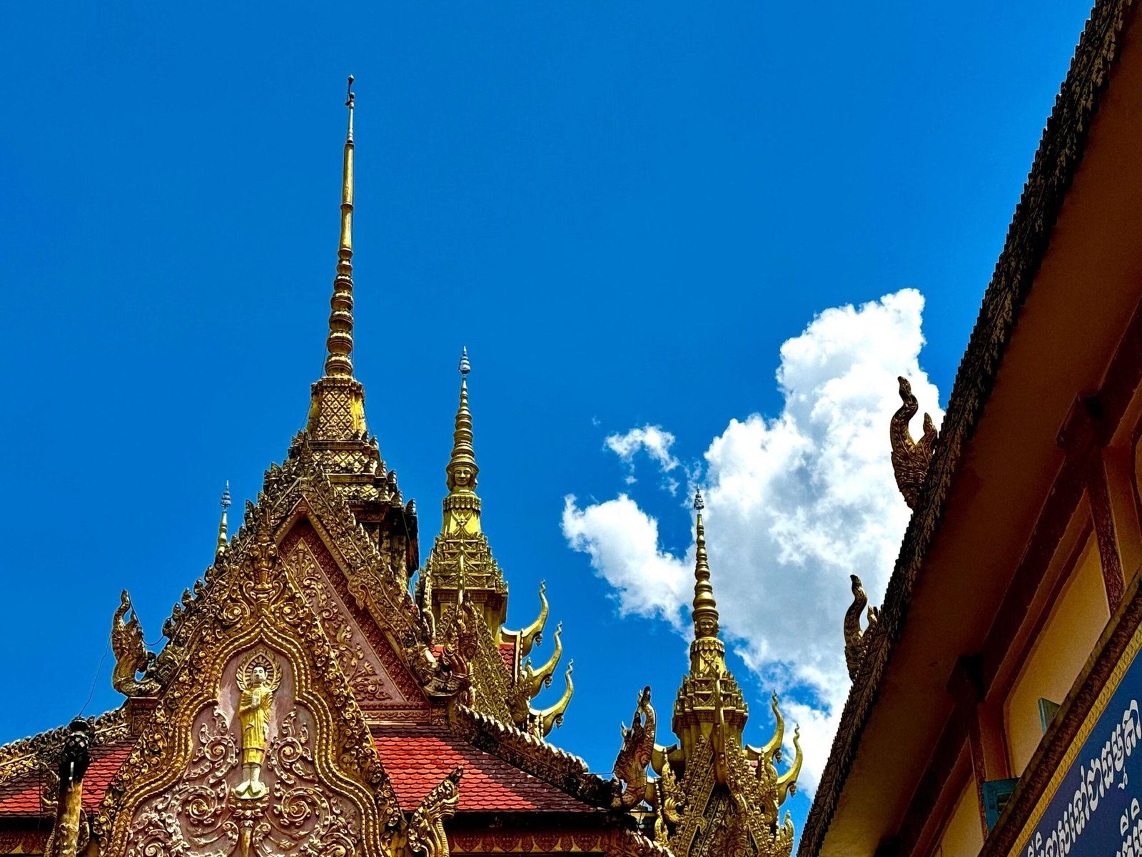 Golden multi-tiered roof of Bat Pagoda in Soc Trang against a blue sky