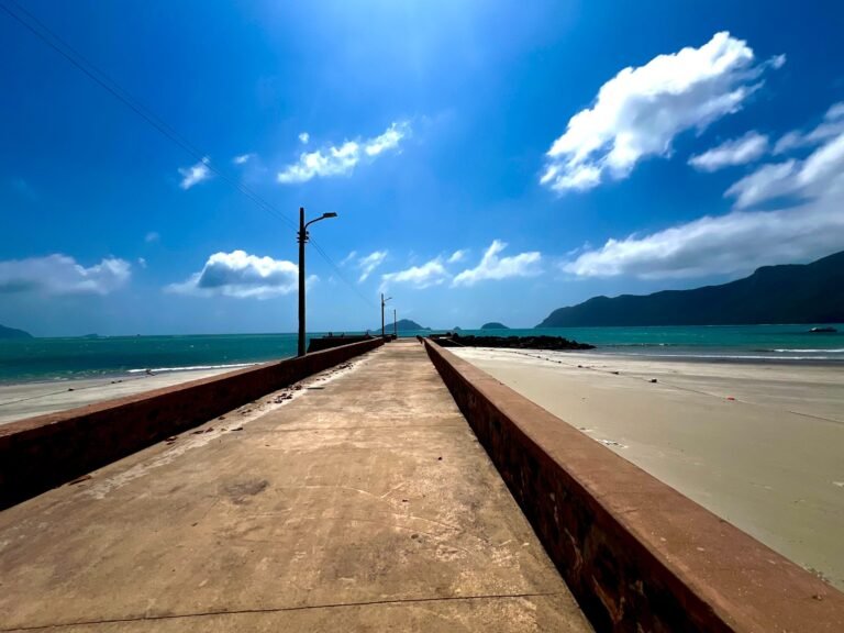 Long concrete pier walkway stretching from a Con Dao beach toward the sea
