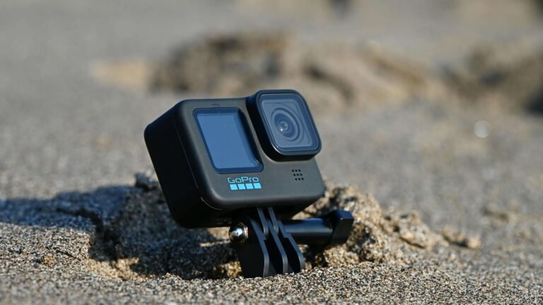 GoPro action camera propped up in beach sand
