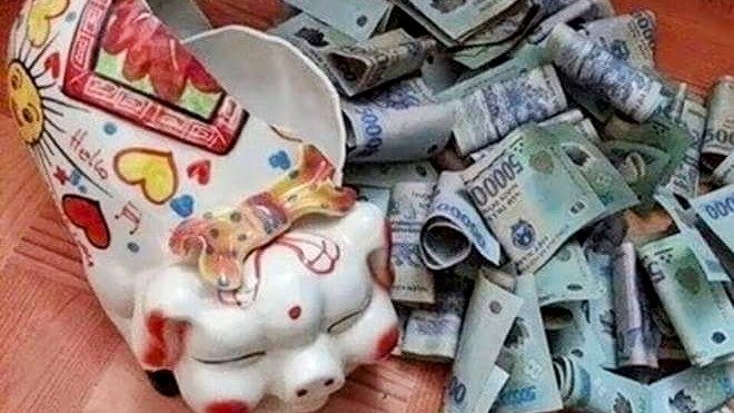 Broken piggy bank spilling Vietnamese dong banknotes